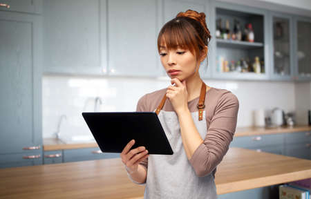 happy woman in apron with tablet pc computer