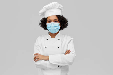 female chef in medical mask and toqueの写真素材
