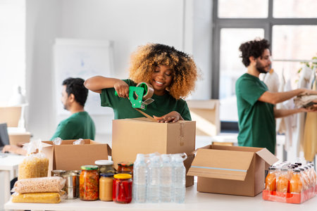 happy volunteers packing food in donation boxesの写真素材