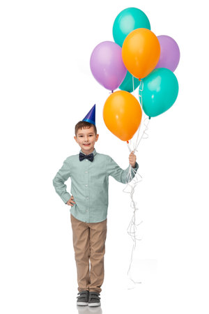 happy boy in birthday party hat with balloonsの写真素材