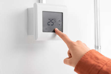 hand setting room temperature on sensor at home