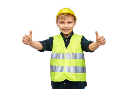 happy boy in construction helmet showing thumbs up