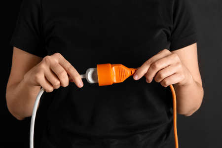 close up of woman inserting plug into socketの写真素材