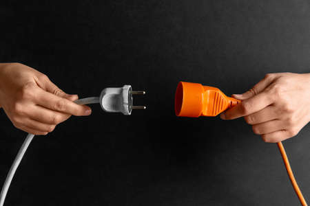 close up of woman inserting plug into socketの写真素材