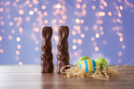 easter eggs in straw nest and chocolate bunniesの写真素材