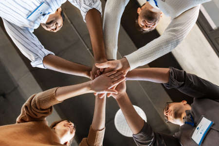 group of business people stacking hands at office