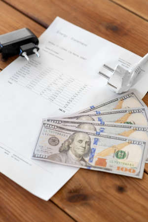 utility bill, money and electric plugs on tableの写真素材