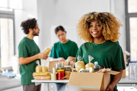 happy volunteers packing food in donation boxesの写真素材