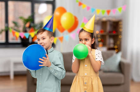 happy children blowing balloons on birthday party