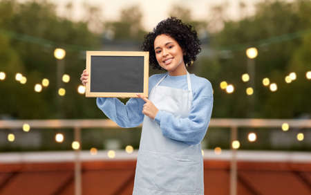 happy woman with chalkboard on restaurant terraceの写真素材