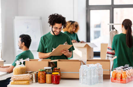 happy volunteers packing food in donation boxesの写真素材