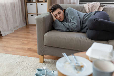 depressed woman lying on sofa at homeの写真素材