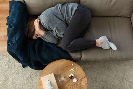 depressed woman lying on sofa at homeの写真素材