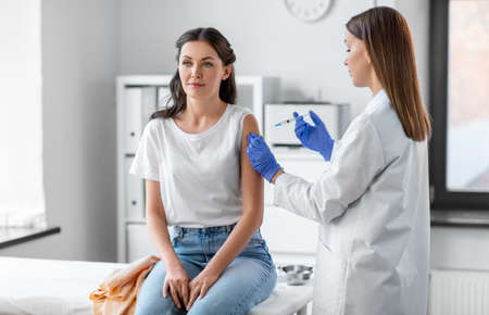 female doctor with syringe vaccinating patient