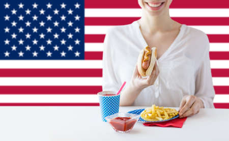 close up of woman eating hotdog and french friesの写真素材