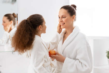 mother and daughter with moisturizer at bathroomの写真素材