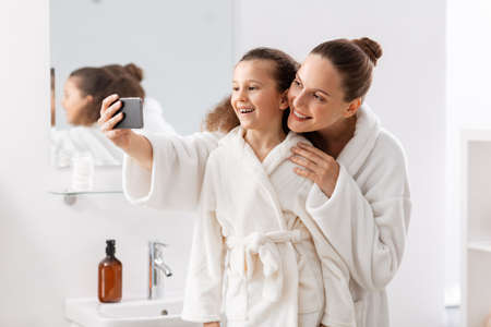 mother and daughter taking selfie with smartphoneの写真素材