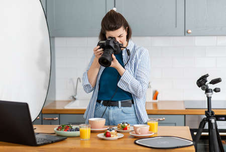 food photographer with camera working in kitchenの写真素材