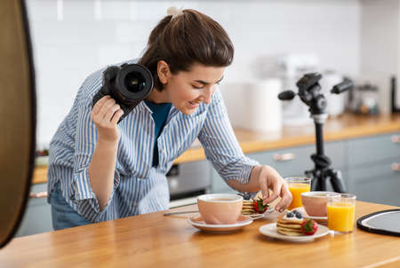 food photographer with camera working in kitchenの写真素材