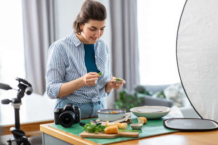 food photographer with camera working in kitchenの写真素材