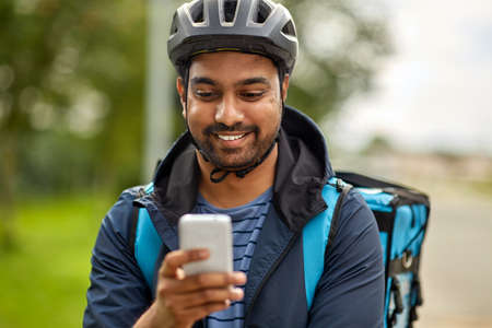 food delivery man with thermal bag and smartphoneの写真素材