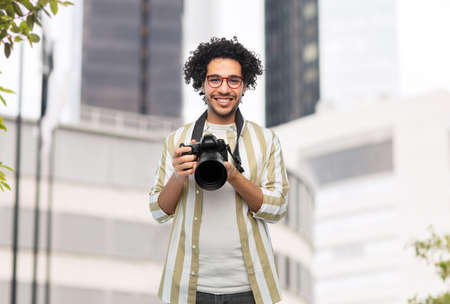 smiling man or photographer with digital cameraの写真素材