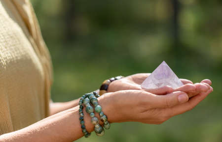 close up of hands holding crystal pyramidの写真素材