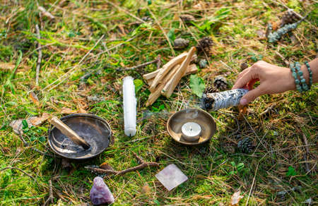 woman or witch performing magic ritual in forest