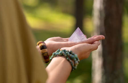close up of hands holding crystal pyramidの写真素材