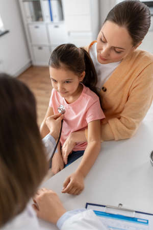 mother, girl and doctor with stethoscope at clinicの写真素材