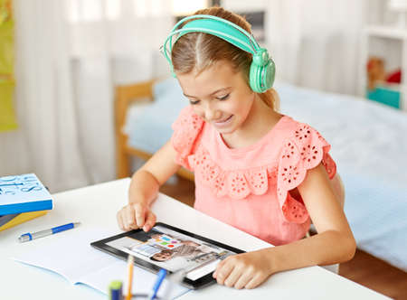 girl with tablet pc having online class at home