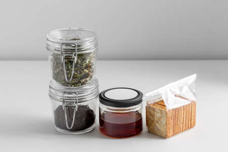 jars with dried herb, tea, honey and cookiesの写真素材