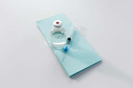 bottle of medicine or vaccine and syringe on table