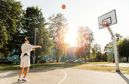 young man playing basketball on outdoor playground