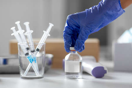 syringes and hand in glove opening medicine