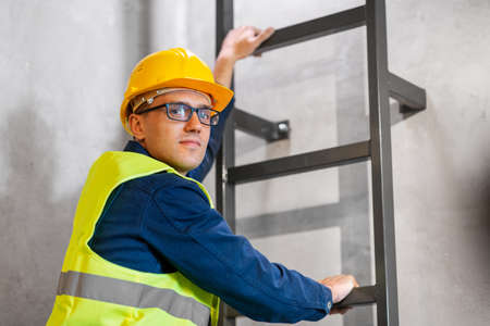 architect in helmet and goggles climbing stairsの写真素材