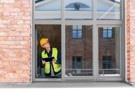 architect in helmet and safety west with tablet pcの写真素材