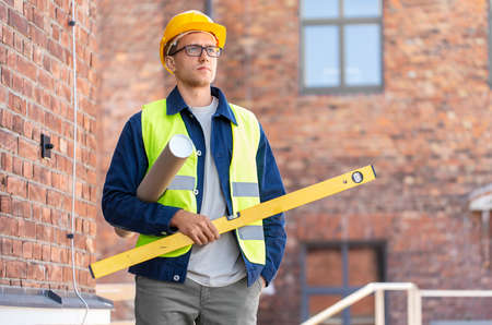 male architect in helmet with level on siteの写真素材