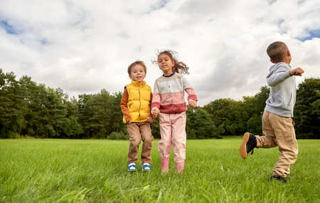 happy children playing and jumping at parkの写真素材