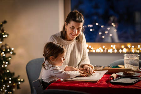 mother and daughter making gingerbread at homeの写真素材