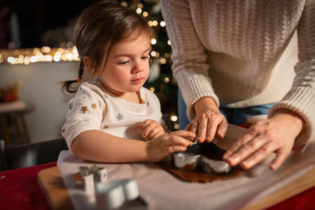 mother and daughter making gingerbread at homeの写真素材