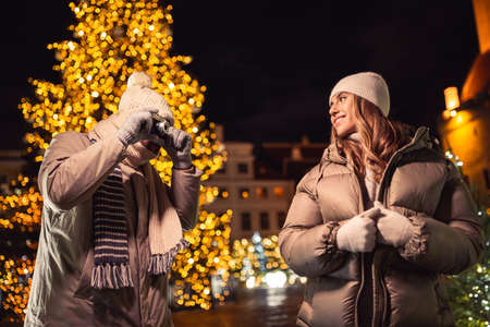 couple with camera photographing at christmas cityの写真素材