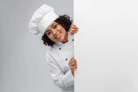 smiling female chef with white boardの写真素材