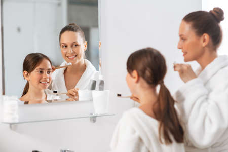 happy mother and daughter brushing teethの写真素材
