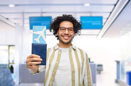 happy man with passport and air ticket at airportの写真素材