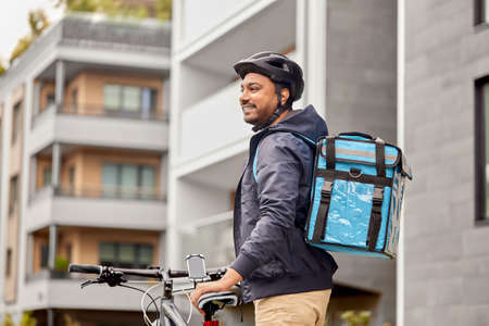 food delivery man with bag and bicycle in cityの写真素材