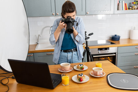 food photographer with camera working in kitchenの写真素材