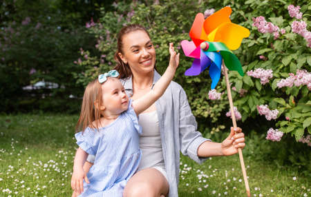 happy mother and daughter with pin wheel at parkの写真素材