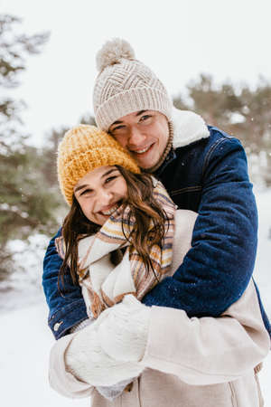 happy smiling couple hugging in winter parkの写真素材