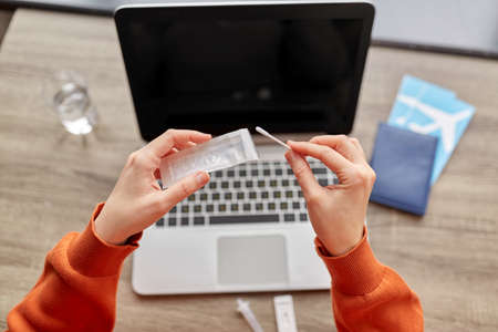 woman with laptop making coronavirus test at home